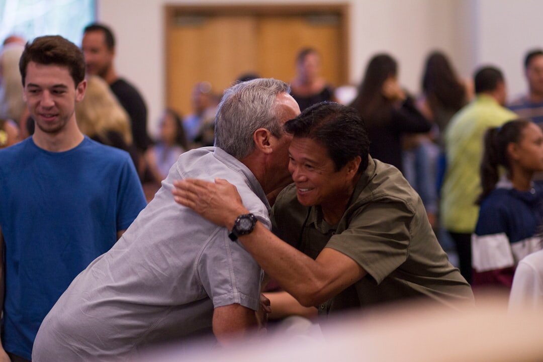 Two celebrities greeting each other warmly at an evening cultural event